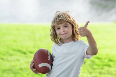 American football. Child ready to throw a football. Sport kids concept. Sport activities for children outdoors