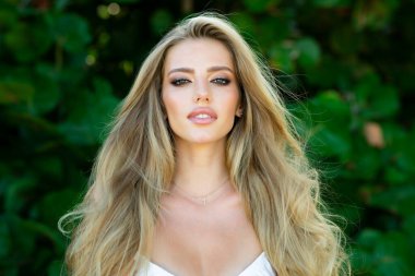 Güzel genç kız bahar parkında dinleniyor. Güzel bir kadının yakın portresi. Yaz parkında güzel bir genç kız. Yaz arkaplanındaki güzel kız modeli.