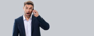 Takım elbiseli bir iş adamı telefonda konuşuyor. Promosyon mobil uygulaması. Stüdyonun arka planında izole edilmiş akıllı telefon kullanan sıradan giyinmiş bir iş adamı. Başlık için afiş, kopyalama alanı. Web tasarımı için poster