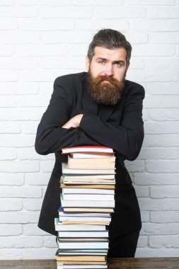 Üniversitede ya da üniversitede. Kitap yığını olan komik bir öğretmen ya da profesörün portresi. Olgun bir öğretmen düşünüyorum. Olgun profesör, orta yaşlı öğretmen, sakallı eğlenceli adam.