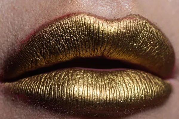 Lip with golden glitter effect. Woman mouth close up. Golden lipstick. Glamour luxury gold mouth. Gold paint on lips. Golden lips on woman mouth. Metallic body. Gold concept