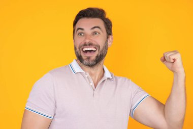 Şaşırmış ifadeli duygusal heyecanlı bir adam. İnsan tepkisi ve duyguları. Yüz ifadesi olan heyecanlı bir adamın stüdyo portresini kapat. Duygusal adam yumruklarını kaldırıyor, başarıyı kutluyor.