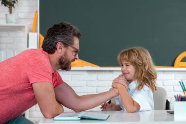 Okula dönelim. Eğitim ve öğrenme kavramı. Baba ve oğul okulda ödev yapıyor.