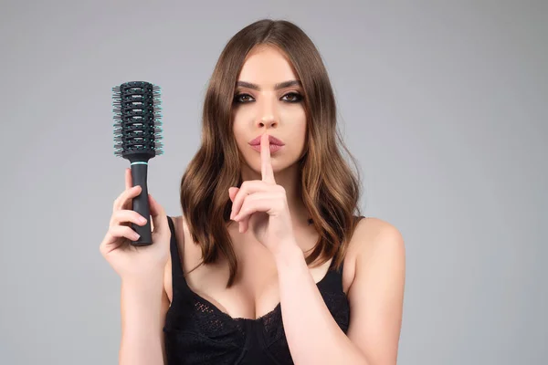 Woman combing her hair. Cares about a healthy and clean hair. Beauty hair salon concept. Girl with a comb in studio. Brushing hair, smooth soft silky hairs effect keratin. Hairs brush