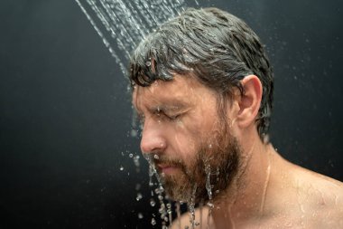 Orta yaşlı bir adam banyoda saç yıkıyor. Küvette banyo yapan adam. Yüzü duşta köpüklü. Banyo yapan adam duş alıyor. Duş alan adamı kapatın. Duş konsepti. İnsan duşta su altındadır.