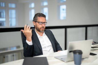 40 'ların yakışıklı iş adamı ofiste dizüstü bilgisayarla çalışıyor. Gri saçlı, olgun iş adamı yönetmeni dizüstü bilgisayar kullanıyor. Ofis işyerinde milenyum müdürü. CEO ofis çalışanları. Ofisteki iş adamları.