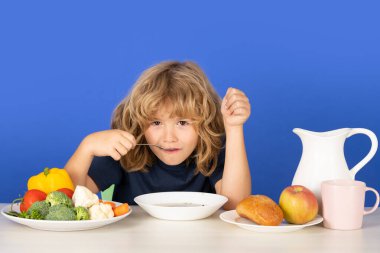 Çocuk yemek yiyor ve çorba içiyor. Çocuk çorba içiyor.