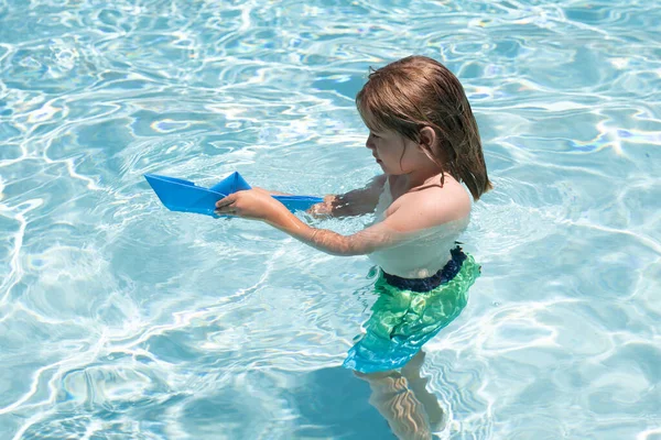 Kind Spelen Het Zwembadwater Met Een Speelgoedboot Een Jochie Dat — Stockfoto