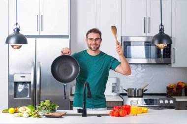 Aşçı mutfakta yemek pişiriyor. Şef aşçı tencereli bir yemek hazırlıyor. Menü tarifi sağlıklı yemek. Şef modern mutfakta yemek pişiriyor. Olgun aşçı mutfakta yemek hazırlıyor.