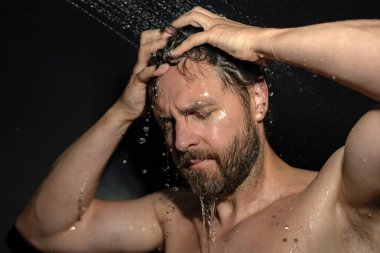 Adam banyoda saç yıkıyor. Küvette banyo yapan adam. Yüzü duşta köpüklü. Banyo yapan adam duş alıyor. Duş alan adamı kapatın. Duş konsepti. İnsan duşta su altındadır.