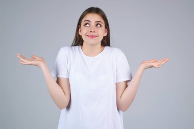 Stüdyonun izole edilmiş arka planında kafası karışmış bir kadının portresi. Kadın düşüncesi, düşünceli bir ifade, düşünceli bir yüz. Şüpheli bir kavram. Ciddi ifade, şüphe ve seçim
