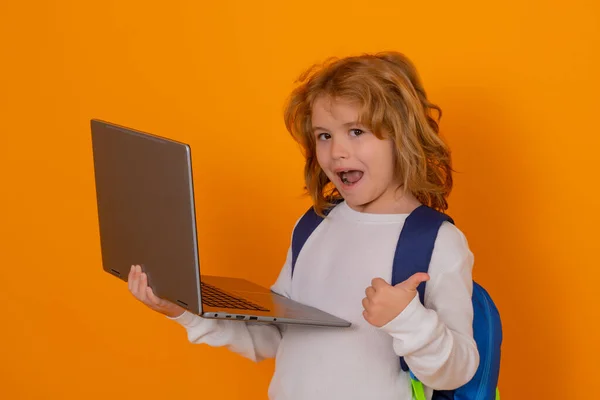 スマートな子供 賢い学校の子供 ラップトップコンピュータを使用して親指の子供 イエロースタジオの背景に孤立した学校の少年像 学校に戻る — ストック写真