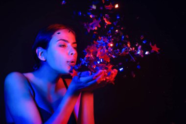 Şehvetli kız konfeti üflüyor. Sevgililer gününde güzel bir genç bayanın portresi. Seksi kadın model doğum gününde ışıldıyor. Doğum gününü kutlayan şehvetli kadın. İyi ki doğdun