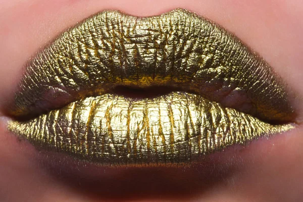 Lip with golden glitter effect. Woman mouth close up. Golden lipstick. Glamour luxury gold mouth. Gold paint on lips. Golden lips on woman mouth. Metallic body. Gold concept