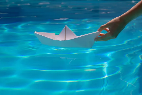 水の上を航行する紙のボートは波と波を引き起こします 紙のボートを水に入れる 折り紙ボート — ストック写真