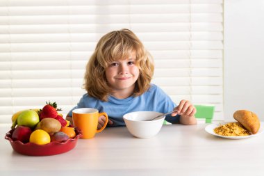 Komik çocuk kahvaltı yapıyor. Süt, sebze ve meyveler çocuklar için sağlıklı besin