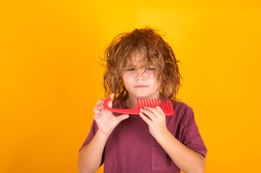 Çocuk berberi. Saçlarını tarayan bir çocuk. Komik çocuk saç kesimi