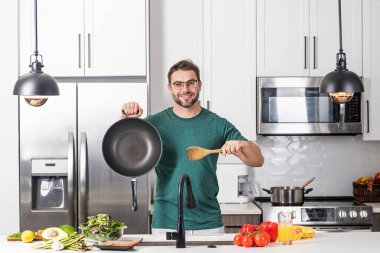 Adam mutfakta yemek pişiriyor. Aşçı şefi tencereli bir yemek hazırlıyor. Menü tarifi sağlıklı yemek. Adam modern mutfakta yemek pişiriyor. Olgun bir adam mutfakta yemek hazırlıyor.