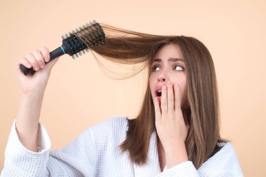 Hair loss woman with a comb and problem hair. Hairloss and hairs problems. Sad girl with damaged hair. Haircare and loss hair problem. Tangling hairs. Girl combing damaged hairs. Alopecia, dandruff