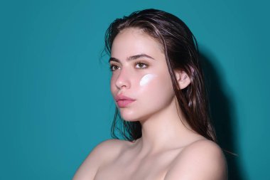 Kozmetik krem süren bir kadın. Yüzüne cilt bakımı yapan spa modeli. Sabah makyajı. Cilt kaldırma ve yaşlanma önleyici etki için nemlendirici cilt kremi, losyon veya maske