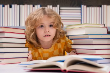 Kütüphanede kitap okuyan bir çocuk. Çocuk gelişimi, okumayı öğrenmek. Öğrenci bir kitapçıda kitap okuyor.