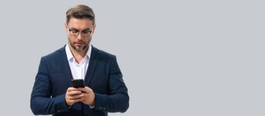 Takım elbiseli adam akıllı telefon kullanıyor. Portre çekici, neşeli adam telefonu kullanıyor, cep telefonundan arıyor. Akıllı telefon stüdyosu özgeçmişi olan yakışıklı bir adam. Banner, boşluğu kopyala