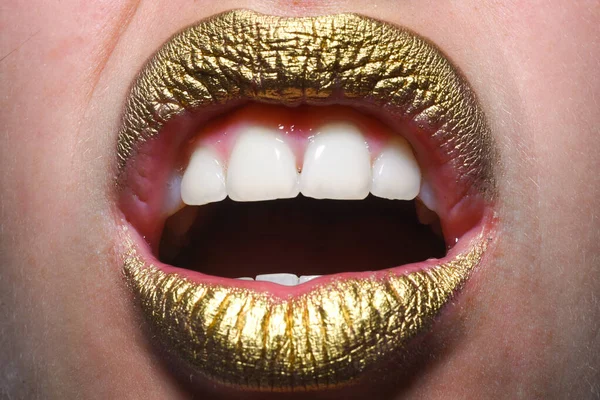 Woman plump lips with gold. Golden glitter lipstick. Shine style for sexy lip. Sensual woman lips. Luxury golden mouth. Glamour gold lips. Golden lips with golden paint or metallic lipstick
