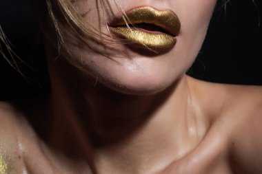 Gold lips, golden lipgloss on sexy lips, metallic mouth. Beauty woman mouth. Sexy girl golden lips, gold mouth. Glowing gold skin and gild lips. Metallic shine golden lip gloss