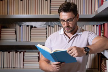 Kütüphanede kitap okuyan bir öğretmen. Öğretmenler günü, öğretmenler günü. Bilgi, eğitim. Kütüphanede ders veren bir öğretmen. Üniversite kütüphanesi. Öğretmenler edebiyat okuyor