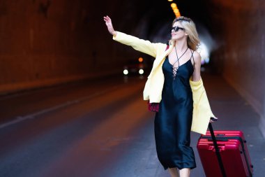 Bavullu kadın taksiye biniyor. Valizli, modaya uygun giyinmiş turist kız. Kadın model hafta sonları yurtdışına çıkıyor. Seyahat kavramı