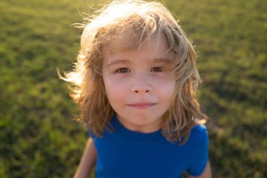 Komik çocuk duyguları. Açık havada, dışarıda oynayan sevimli küçük bir çocuğun portresi. Dışarıdaki güzel çocukların portresi.