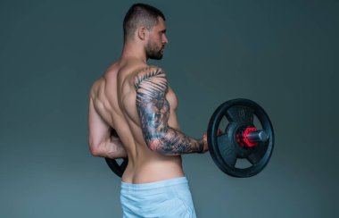 Seksi bir vücut. Sporcu kaslı adam spor salonunda çalışıyor. Dambılla egzersiz yapan atletik adam. Spor, spor konsepti, spor kulübü, fitness merkezi. Mükemmel kasları olan seksi bir vücut geliştirici.