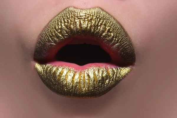 Sexy gold lips, golden lipgloss on sexy lips, metallic mouth. Sensual woman mouth. Sexy girl golden lips, gold mouth. Glowing gold skin and gild lips. Metallic shine golden lip gloss