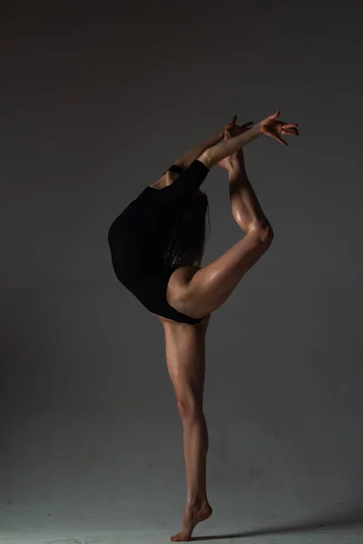 柔軟な女の子の踊り 美しい柔軟な女性の体 黒の上にフィットセクシー柔軟な女性のファッションアートスタジオの肖像画 体操のスリムと柔軟なダンサーの女性が実行します ストレッチ運動 — ストック写真