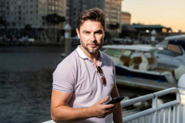 Günlük kıyafetleriyle Tampa 'da gezen şehir tarzı bir adam. Amerikan şehrinde günlük kıyafetleri olan çekici bir adamın portresi. Şehir modasında yakışıklı bir genç adam sokakta yürüyor.