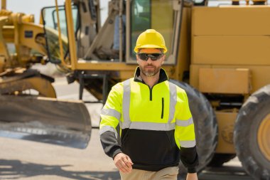 İnşaat işçisi inşaat halinde. Erkek inşaatçı inşaat alanında çalışıyor. Amerikan inşaat sahasında miğferli mühendis portresi.