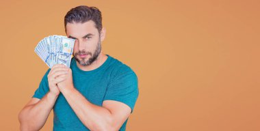 Başarılı adam para sayıyor. Yakışıklı orta yaşlı adam 100 dolarlık banknotları tutuyor. Elinde para tutan adam. Dolar nakiti olan bir iş adamı.