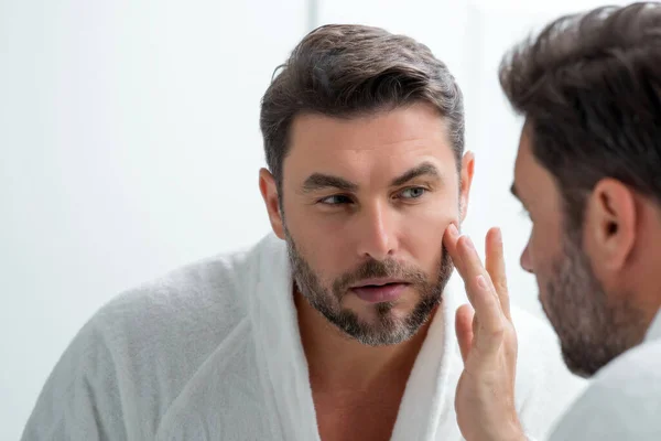 白种人的美男子使用润肤面霜为健康的皮肤 男性护肤的概念 男性美容和皮肤护理肖像 剃须后的健康清洁脸 面部处理 护肤概念 — 图库照片