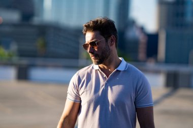 Şehirde kendine güvenen yakışıklı bir adamın portresi. Modern büyük Amerikan şehrinde kendine güvenen bir adamın portresi. Şık bir Lambersex modeli. Polo giymiş seksi bir adam. Moda erkeği Tampa 'da sokakta poz veriyor.