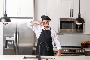 Aşçı aşçı adam. Milenyum aşçı üniformalı erkek şef. Aşçı mutfakta yemek pişiriyor. Aşçı şapkalı ve önlüklü