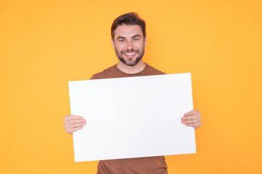 Boş tabela, reklam panosu ya da fotokopi alanı olan pano. Mutlu, yakışıklı, gülümseyen orta yaşlı adam stüdyo arka planında reklam panosu gösteriyor. Reklam konsepti. Boş model.