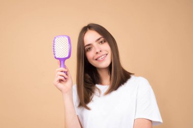 Saçlarını tarayan çekici bir kadın. Saçlarını tarayan güzel bir kız. Saç bakım konsepti