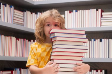 Okul ve eğitim kavramı. Okuldaki çocuk. Öğrenci çocuk kütüphanede kitap okuyor. Çocuk gelişimi. Öğrenci okumayı öğreniyor. İlkokuldan bir çocuk bir kitapçıda kitap okudu.