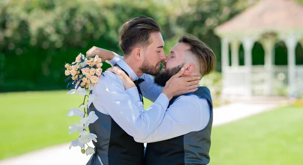 gay kiss on wedding. marriage gay couple tender kissing. close up portrait of gay kissed. Gay couple holding bouquet of flower together during wedding ceremony