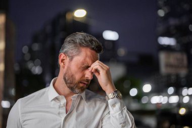 Stresli bir iş adamının gece şehir geçmişindeki portresini yakından çek. Stresli CEO 'nun dışarıda stres ve baş ağrısı var. Gece sokağında serbest çalışan yorgun bir adam. Yorgun iş çok çalışan adam