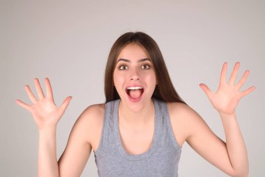 Şaşırmış ifadeli duygusal heyecanlı kadın. İnsan tepkisi ve duyguları. Yüz ifadesi olan heyecanlı kadının stüdyo portresini kapat. Duygusal kız yumruklarını kaldırıyor, başarıyı kutluyor.