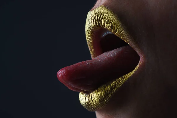 Sensual tongue licking lips. Golden glitter lipstick. Shine style for sexy lip. Sensual woman lips. Luxury golden mouth. Glamour gold lips. Golden lips with golden paint or metallic lipstick