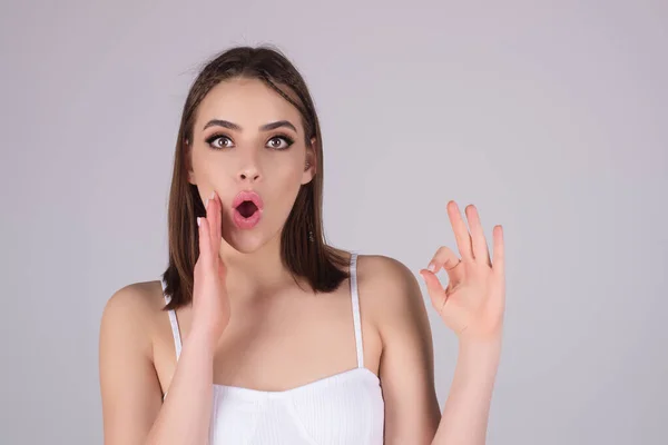 Surprised shocked young girl isolated over studio background. Close up shot of emotive shocked young woman opens mouth widely, Wow, unbelievable. People expressive emotions