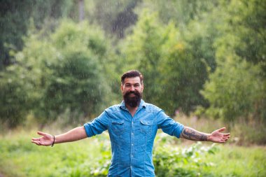 Yağmur altındaki mutlu adam. Rahatlama konsepti. Olumlu düşün. Fırtınalı hava. Yağmurda meditasyon.