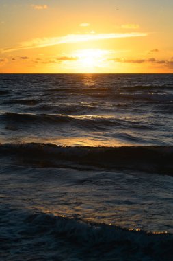 Tropikal deniz okyanusunda gün batımı ve gündoğumu bulutları. Seyahat tatili afişi. Manzara gökyüzü ve yansıma ışınları. Alacakaranlık, denizde alacakaranlık. Sakin, altın gökyüzü arka planı
